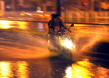 A motorbike runs on a flooded street in Beijing, capital of China, July 31, 2009. A heavy rain hit Beijing on Thursday evening and caused traffic jam. [Luo Xiaoguang/Xinhua] 