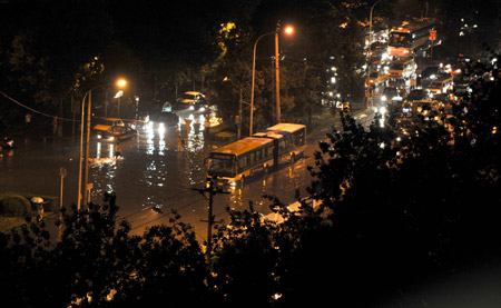 Vehicles are seen on a flooded street in Beijing, capital of China, July 31, 2009. A heavy rain hit Beijing on Thursday evening and caused traffic jam. [Wang Yuguo/Xinhua]