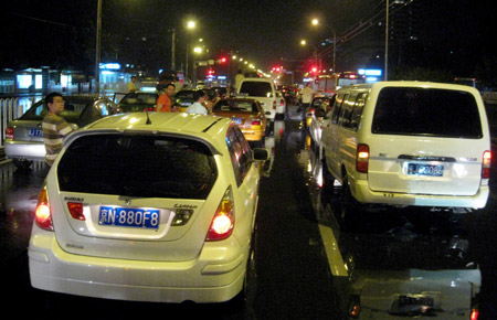 Vehicles halt on a flooded street in Beijing, capital of China, July 31, 2009. A heavy rain hit Beijing on Thursday evening and caused traffic jam. Chen [Jianli/Xinhua]