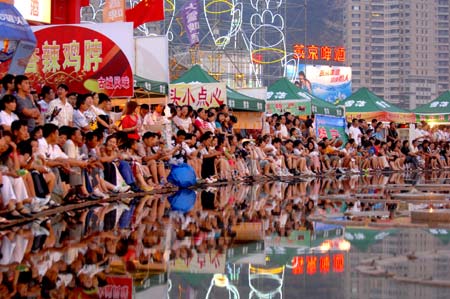 Revellers view the performance during the 11th China International Beer Festival in Dalian, a coastal city in northeast China's Liaoning Province, July 30, 2009. The festival opened here on Thursday. More than 30 breweries from China, Germany, the United States and the Republic of Korea attended the festival with over 400 beer brands.[Yao Jianfeng/Xinhua]