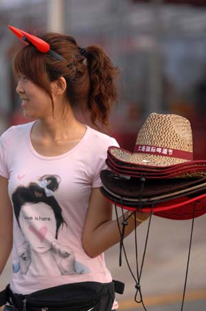 A girl sells hats during the 11th China International Beer Festival in Dalian, a coastal city in northeast China's Liaoning Province, July 30, 2009. The festival opened here on Thursday. More than 30 breweries from China, Germany, the United States and the Republic of Korea attended the festival with over 400 beer brands.[Yao Jianfeng/Xinhua]