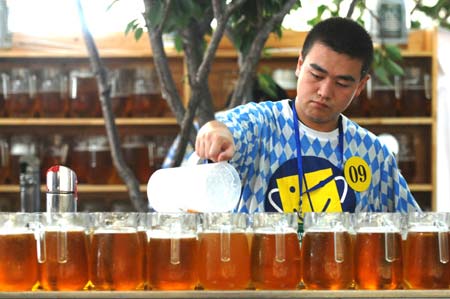 A man pours beer during the 11th China International Beer Festival in Dalian, a coastal city in northeast China's Liaoning Province, July 30, 2009. The festival opened here on Thursday. More than 30 breweries from China, Germany, the United States and the Republic of Korea attended the festival with over 400 beer brands.[Yao Jianfeng/Xinhua]