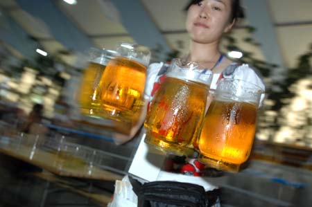 A waitress holds beer cups during the 11th China International Beer Festival in Dalian, a coastal city in northeast China's Liaoning Province, July 30, 2009. The festival opened here on Thursday. More than 30 breweries from China, Germany, the United States and the Republic of Korea attended the festival with over 400 beer brands.[Yao Jianfeng/Xinhua]