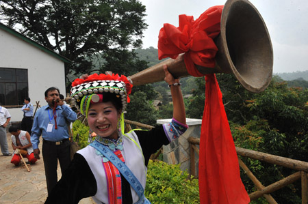 A foreign tourist (L) learns to play a traditional musical instrument of the Yi ethnic group at Keyi Village of Mile County, southwest China's Yunnan Province, July 29, 2009.(Xinhua/Chen Haining) 
