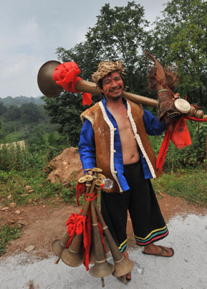 A resident of the Yi ethnic group is seen with his musical instruments at Keyi Village of Mile County, southwest China's Yunnan Province, July 29, 2009. (Xinhua/Chen Haining)