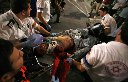 Israeli paramedics move a wounded man into an ambulance after a shooting incident in a basement club in central Tel Aviv Aug. 1, 2009. [Xinhua/AFP]