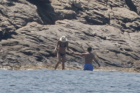 France's President Nicolas Sarkozy assists his wife Carla Bruni-Sarkozy into the water as they start their holidays at the villa belonging to the family of France's first lady at Cap Negre, near Cavaliere, August 1, 2009. [Xinhua/Reuters]