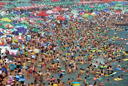 Thousands of people flock to a bathing beach to cool themselves in Dalian, northeast China's Liaoning Province, Aug. 1, 2009.[Wang Jianmin/Xinhua]