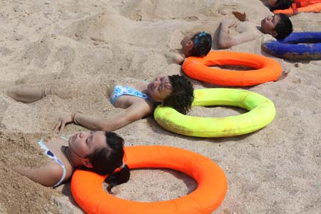 Tourists enjoy sand bath in Suma Bay beach in Lianyungang, east China's Jiangsu Province, Aug. 1, 2009. Thousands of people flocked to the bathing beach to cool themselves.[Wang Jianmin/Xinhua]