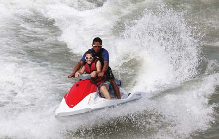 Tourists enjoy the excitement of riding motorboat in Lianyungang, east China's Jiangsu Province, Aug. 1, 2009. Thousands of people flocked to a bathing beach to cool themselves.[Wang Jianmin/Xinhua]