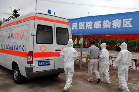 Chinese medics escort a 'patient' of influenza A/H1N1 during a drill for the flu prevention in Xiuning County of Huangshan, in east China's Anhui Province, Aug.2, 2009.[Liu Bingsheng/Xinhua]