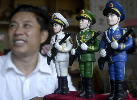 Handicraftsman Mu Chujian shows his sculptures made of flour, portraying soldiers during Chinese People's War of Resistance Against Japanese Aggression in Heze, a city of east China's Shandong Province, August 2, 2009. [Xinhua]