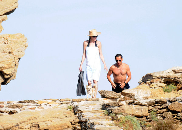 French President Nicolas Sarkozy and his Wife Carla Bruni-Sarkozy head for home after a swim in the sea during their holiday at 'le Cap Negre' on July 31, 2009 in Le Lavandou, France. [CFP]