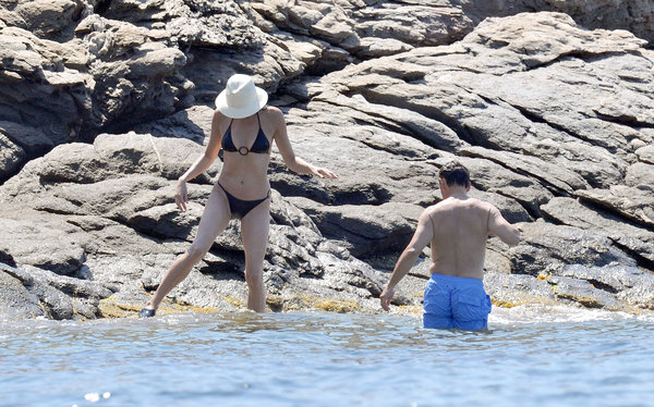 France's President Nicolas Sarkozy (R) and his wife Carla Bruni-Sarkozy descend rocks into the Mediterranean Sea below the villa belonging to the family of France's first lady which is perched on the secluded promontory of Cap Negre, near Cavaliere, August 1, 2009. [CFP] 