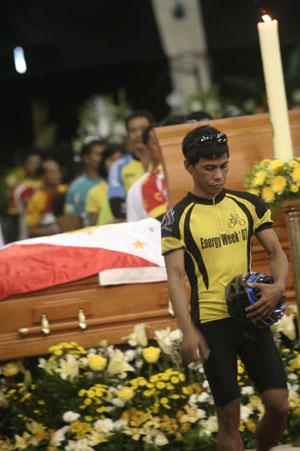 A Philippine cyclist walks out after viewing the remains of late Philippine President Corazon Aquino at La Salle school gym in suburban Mandaluyong, east of Manila, Aug. 2, 2009.[Luis Liwanag/Xinhua]