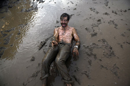 A concert goer plays in the mud during the All Points West music festival at Liberty State Park in Jersey City, New Jersey August 2, 2009. [Xinhua/Reuters]