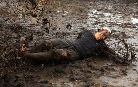 A concert goer plays in the mud during the All Points West music festival at Liberty State Park in Jersey City, New Jersey August 2, 2009. [Xinhua/Reuters]