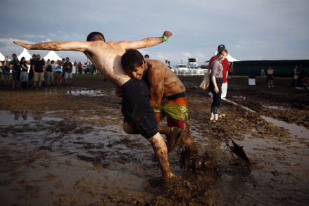 Concert goers play in the mud during the All Points West music festival at Liberty State Park in Jersey City, New Jersey August 2, 2009. [Xinhua/Reuters]