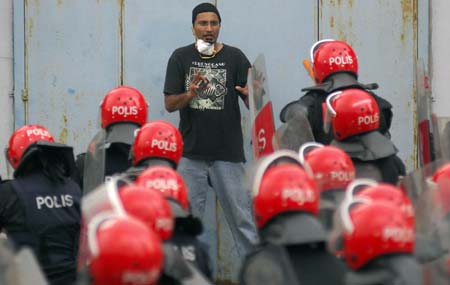 A demonstrator pleads with riot police during a protest against the Internal Security Act (ISA) in downtown Kuala Lumpur August 1, 2009. Malaysian police fired tear gas and detained about 180 people on Saturday to break up an opposition-led rally of over 5,000 people protesting against ISA, a security law that allows detention without trial.[Xinhua/Reuters]