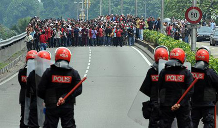 Protestors and riot police confront in Kuala Lumpur, capital of Malaysia on August 1. More than 30,000 people took part in a massive demonstration against the Internal Security Act (ISA) in the city towards the National Palace to hand over a memorandum to the King on the abolishment of the ISA. [Xinhua/AFP]