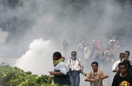 Demonstrators and journalists run away from tear gas during a protest against the Internal Security Act (ISA) in downtown Kuala Lumpur August 1, 2009. [Xinhua/Reuters]