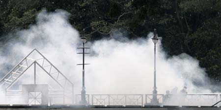 Demonstrators cover themselves from tear gas during a protest against the Internal Security Act (ISA) in downtown Kuala Lumpur August 1, 2009. The ISA is a law that allows for detention without trial.[Xinhua/Reuters]