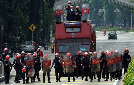 Roit police are ready to throw tear shell to disperse the massive demonstrators in Kuala Lumpur, capital of Malaysia on August 1. More than 30,000 people took part in the massive demonstration against the Internal Security Act (ISA) in the city towards the National Palace to hand over a memorandum to the King on the abolishment of the ISA. [Xinhua/AFP]