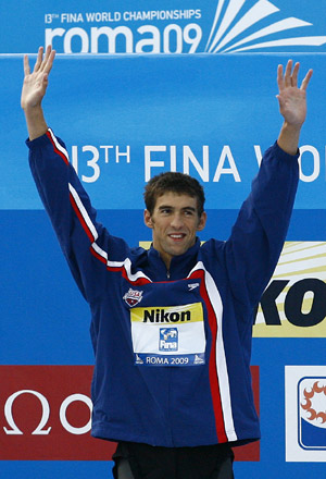 Michael Phelps of the U.S. celebrates on the podium during the awarding ceremony of the men's 100m butterfly final at the 13th FINA World Championships in Rome, Aug. 1, 2009.(Xinhua/Zhang Yuwei)