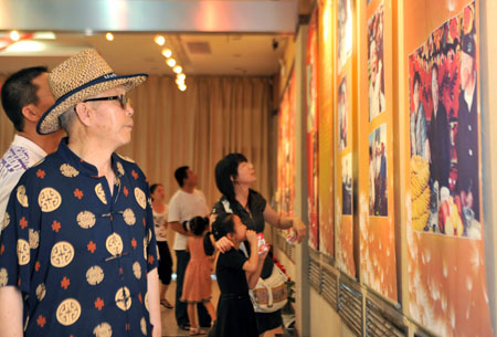 Citizens view pictures at the photo exhibition titled 'We Are One Family' at the Museum of Urumqi, northwest China's Xinjiang Uygur Autonomous Region, August 1, 2009.(Xinhua/Jiang Wenyao) 