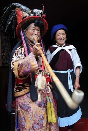 Two elders of the Naxi ethnic group are seen in Lijiang, southwest China's Yunnan Province, on July 29, 2009. Lijiang received 3.44 million tourists in the first half of 2009, earning a tourism income of 3.88 billion RMB yuan (568 million U.S. dollars). Lijiang with an 800-year history was listed by the UNESCO in 1997 as a world cultural heritage site. (Xinhua/Lin Yiguang) 