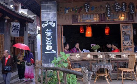 Tourists enjoy themselves in Lijiang, southwest China's Yunnan Province, on July 27, 2009. Lijiang received 3.44 million tourists in the first half of 2009, earning a tourism income of 3.88 billion RMB yuan (568 million U.S. dollars). Lijiang with an 800-year history was listed by the UNESCO in 1997 as a world cultural heritage site. (Xinhua/Lin Yiguang)