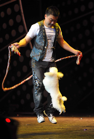 An actor performs skipping with a dog during a 'Happy Stage' show at the Puppet Theater in Beijing, capital of China, Aug. 1, 2009. 