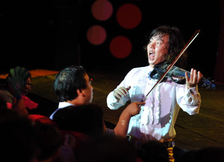 An actor plays violin during a 'Happy Stage' show at the Puppet Theater in Beijing, capital of China, Aug. 1, 2009.
