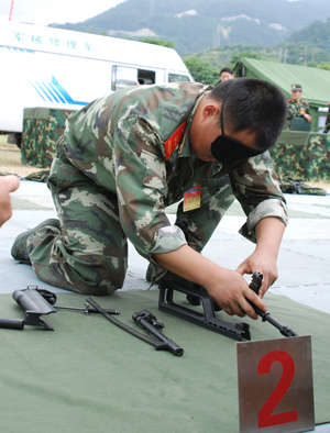 A Chinese armed policeman assembles a weapon as he participates in a skill competition during a para-military logistic exercise in Fuzhou, capital of southeast China's Fujian Province, August 3, 2009.[Zeng Zhaoqun/Xinhua]