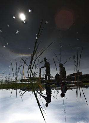 A couple of Bai ethnic group go fishing in the sun on West Lake, in Eryuan County, Dali Bai Autonomous Prefecture, southwest China's Yunnan Province, Aug. 3, 2009. Dali is the only autonomous prefecture of Bai ethnic group in China and has a population of 3,470,000 with one third of which from Bai.[Fei Maohua/Xinhua]