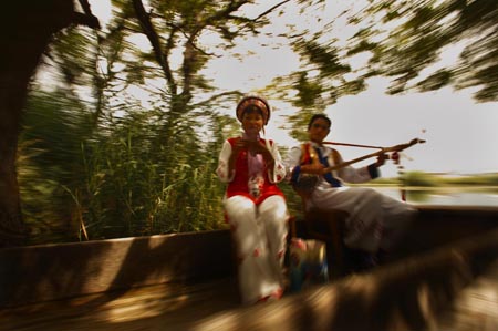 Young singers of Bai ethnic group sing folk songs for tourists on West Lake, in Eryuan County, Dali Bai Autonomous Prefecture, southwest China's Yunnan Province, Aug. 3, 2009. Dali is the only autonomous prefecture of Bai ethnic group in China and has a population of 3,470,000 with one third of which from Bai.[Fei Maohua/Xinhua]