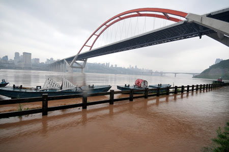 The flood peak of this year's highest level in the Yangtze River flows past under a bridge in southwest China's Chongqing Municipality, August 3, 2009. [Zhong Guilin/Xinhua]