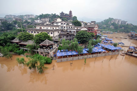 The flood peak of this year's highest level in the Yangtze River flows past a wharf near southwest China's Chongqing Municipality, August 3, 2009. Emergency departments of the local authority are keeping high alert as some places were submerged.[Xinhua]