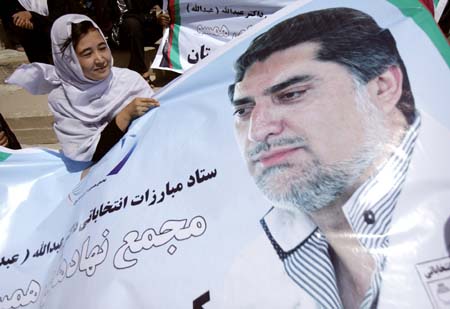 A woman holds a banner of Afghan presidential candidate Abdullah Abdullah at a rally for him in Kabul Stadium August 3, 2009.[Xinhua/Reuters]