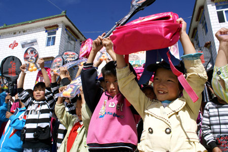 Children show the articles they received at Tibet Children's Welfare Home in Lhasa, capital of southwest China's Tibet Autonomous Region, August 1, 2009. A group of armed policemen paid a visit to Tibet Children's Welfare Home on Saturday and brought children living and learning articles. [Liang Jianming/Xinhua]