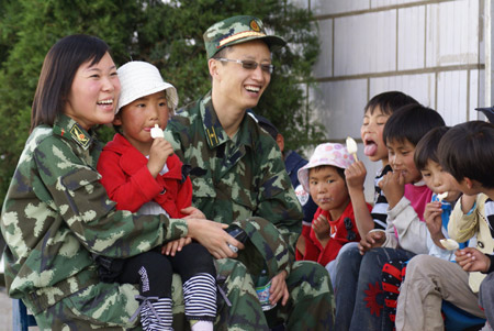  Soldiers chat with children at Tibet Children's Welfare Home in Lhasa, capital of southwest China's Tibet Autonomous Region, August 1, 2009. A group of armed policemen paid a visit to Tibet Children's Welfare Home on Saturday and brought children living and learning articles. [Liang Jianming/Xinhua] 