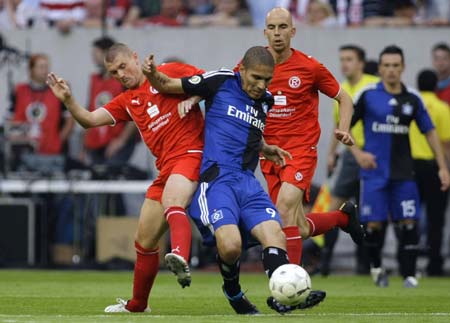 Fortuna Duesseldorf's Marco Christ (L) tackles Hamburger SV's Paolo Guerrero (C) during their German soccer cup (DFB-Pokal) match in Duesseldorf August 3, 2009.