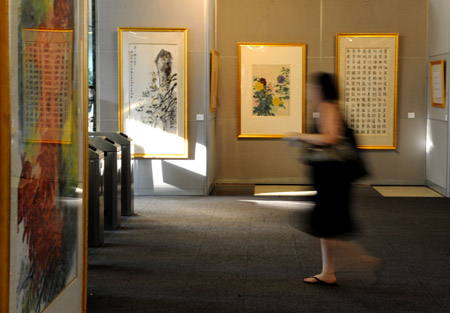 A woman walks past works at the exhibition of 'Sound of Ink' by Chinese artist Zhou Suyin at the U.N. headquarters in New York, on Aug. 3, 2009. The exhibition of 'Sound of Ink' was opened here on Monday. 