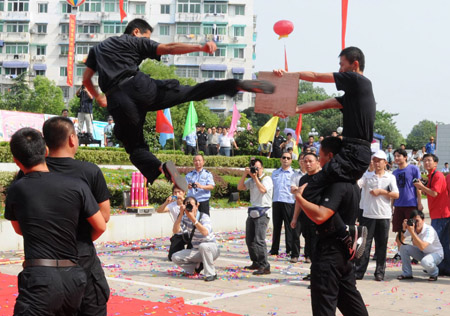 A Chinese policeman breaks a slate of stone in the air with his foot as he shows his skills for the public during a police camp open day in Jingdezhen city in east China's Jiangxi Province, August 4, 2009. [Shi Weiming/Xinhua]