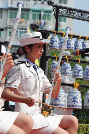 A Chinese policewoman and her colleagues play Chinese traditional musical instruments for the public during a police camp open day in Jingdezhen city in east China's Jiangxi Province, August 4, 2009.[Shi Weiming/Xinhua]