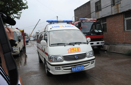 An ambulance waits at the site where a factory under construction collapsed and at least 17 people were killed at Xizhaotong Township, Shijiazhuang City, capital of north China's Hebei Province, Aug. 4, 2009.[Gong Zhihong/Xinhua] 