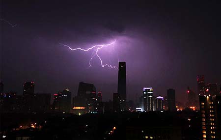 A flash of lightning splits the night sky of Beijing on July 12, 2009, in this photo issued on gb.cri.cn. The lightning is quite near China's World Trade Centre, which is the highest building in Beijing.[CRI]