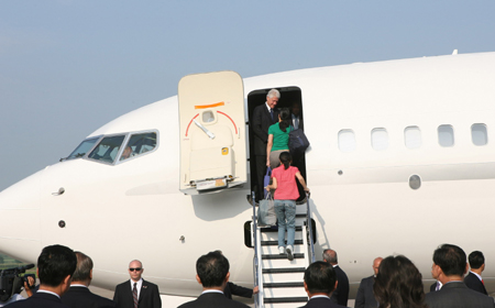 The two female American journalists just amnestied by the Democratic People's Republic of Korea (DPRK) go aboard a chartered plane carrying the homebound former U.S. president Bill Clinton to leave Pyongyang, capital of the DPRK, on Aug. 5, 2009. [Zhang Binyang/Xinhua]