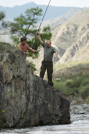 Russia's Prime Minister Vladimir Putin (R) fishes in southern Siberia's Tuva region, August 3, 2009. Picture taken August 3, 2009. [Xinhua/Reuters]