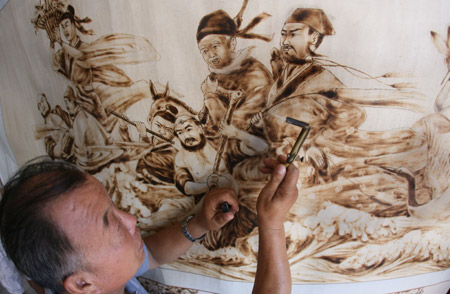 Folk artist Yu Hua paints 'Baxian Guohai', a picture depicting a fairy tale of eight immortals, with a 'fire brush' at home in Yongji City of north China's Shanxi Province, August 4, 2009. Yu Hua has created over 400 pieces of fire-painted artworks, since he created the special way of painting several years ago with a 'fire brush' scorching on the canvas made of white cloth and plank. [Xue Jun/Xinhua]